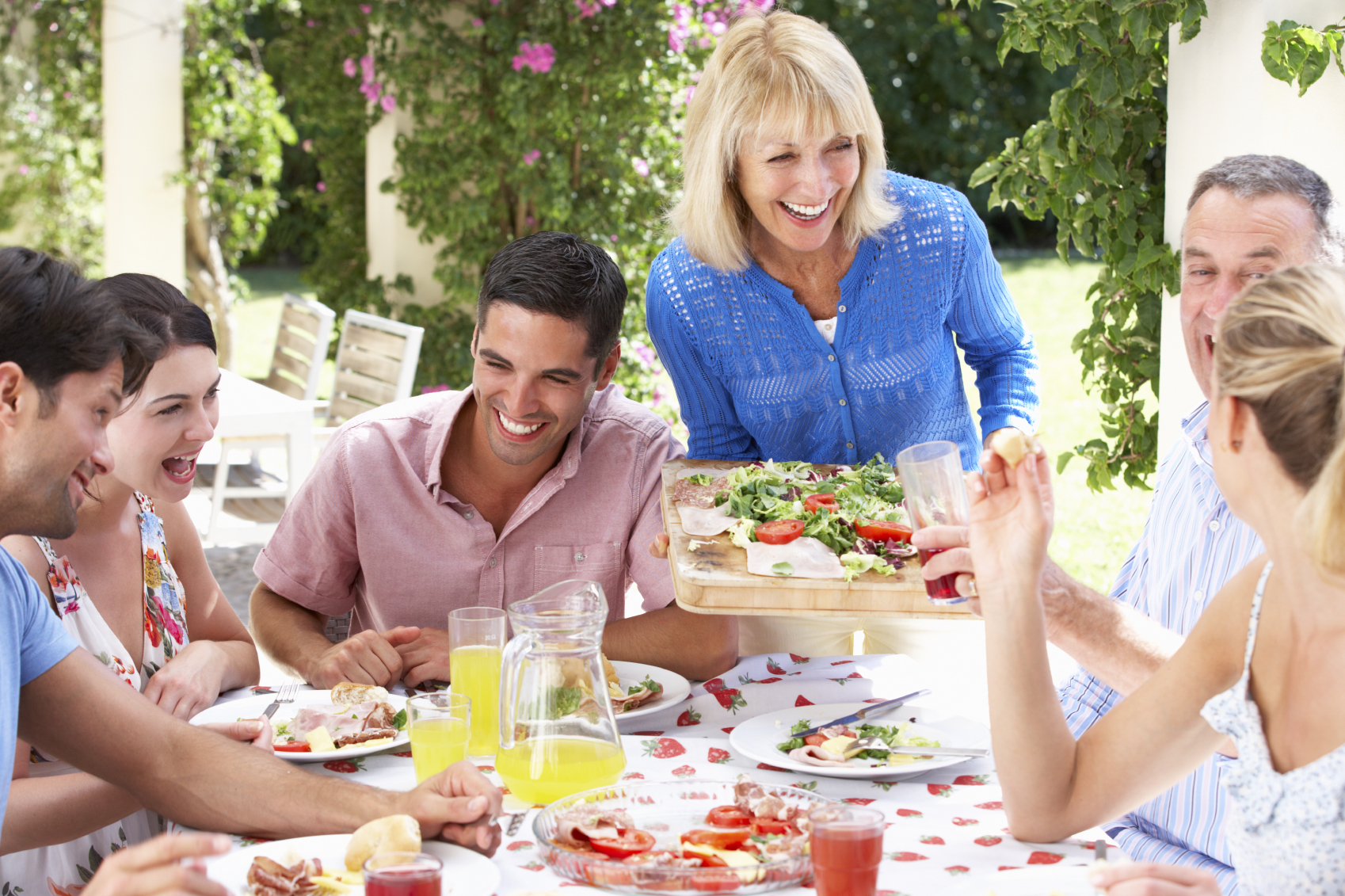 Group Of Young And Senior Couples Enjoying Family Meal